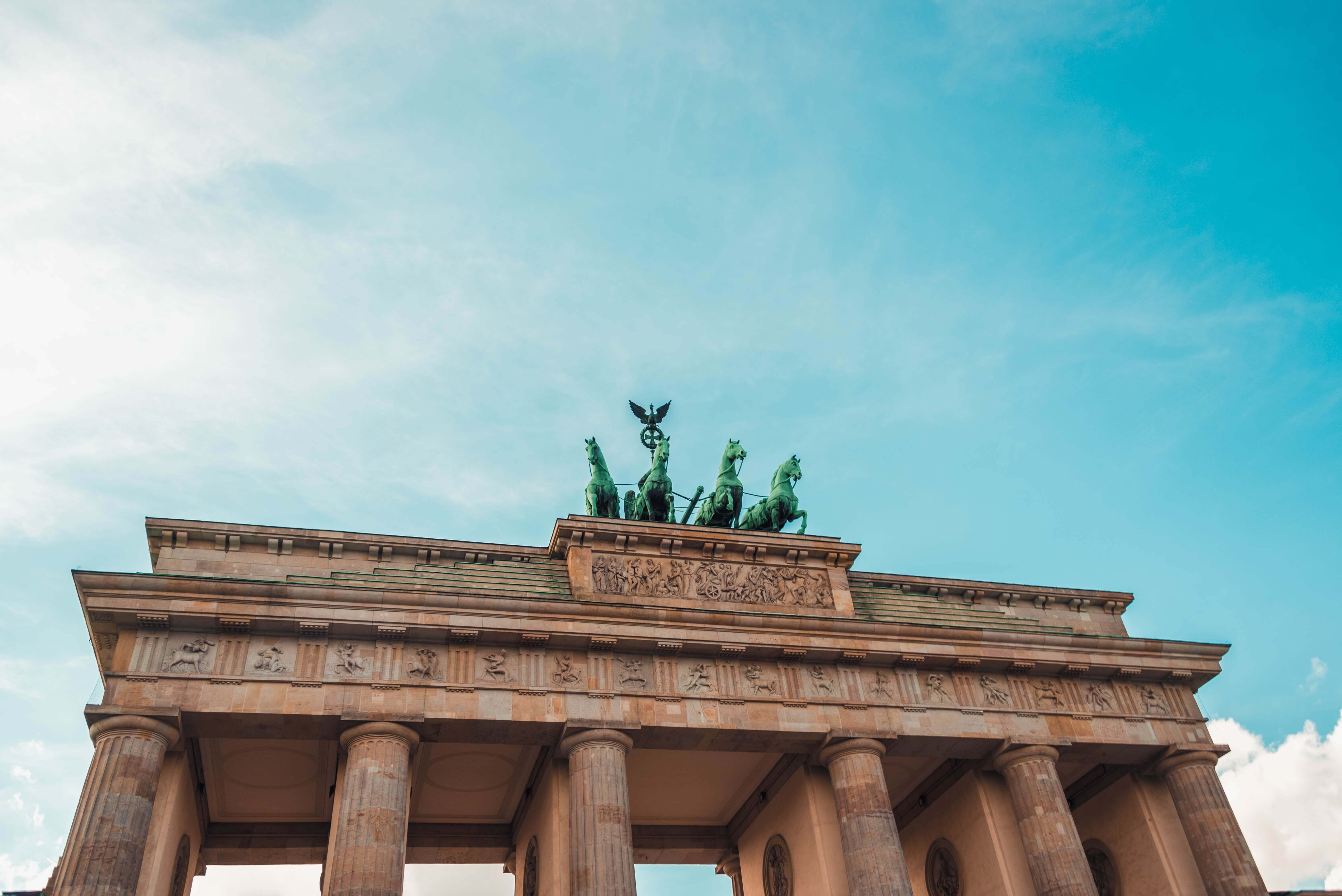 The Brandenburg Gate in Berlin, Germany, under a clear blue sky, featuring classical columns and a quadriga sculpture of a chariot drawn by four horses on top, perfect for your Instagram scheduler | plannthat.com